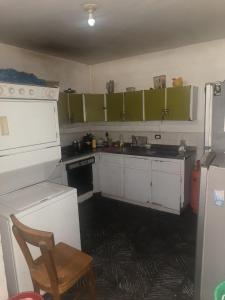 a kitchen with green cabinets and a white refrigerator at Habitacion privada Rosales in Medellín