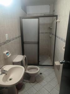 a bathroom with a shower and a toilet and a sink at Habitacion privada Rosales in Medellín