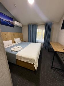 a hotel room with a bed with towels on it at Premium 777 Hotel in Yakkasaray