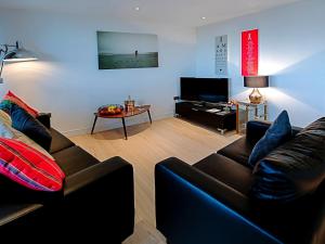 a living room with a couch and a tv at No1 The Two Bedroom Balcony View in Portsmouth