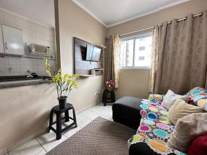 ein kleines Wohnzimmer mit einem Sofa und einem Fenster in der Unterkunft Apto c/ vista mar e piscina no prédio perto do mar in Samaritá