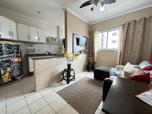 ein Wohnzimmer mit Couch und Küche in der Unterkunft Apto c/ vista mar e piscina no prédio perto do mar in Samaritá