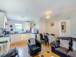 une cuisine et un salon avec un canapé et une table dans l'établissement Snowdrop Cottage - W43121, à Goxhill