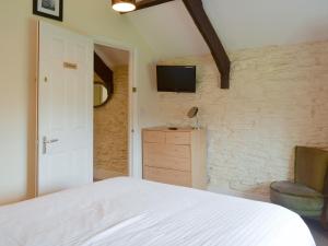 ein Schlafzimmer mit einem Bett und einem Fernseher an der Wand in der Unterkunft Paddock Cottage - Ukc3783 in West Down