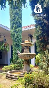 a fountain in a yard in front of a building at Paraíso Real in Buga