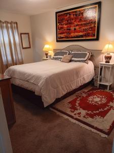a bedroom with a large bed with two lamps and a rug at Beach View Bungalow in Gulfport