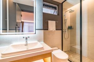 a bathroom with a sink and a shower at Floral Hotel Beijing Heyuan Courtyard Luxury Hotel in Beijing