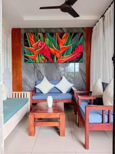 ein Wohnzimmer mit einer Couch und einem Gemälde an der Wand in der Unterkunft Casa Green Kori in Kerobokan