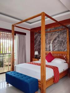 ein Schlafzimmer mit einem hölzernen Himmelbett mit einer blauen Bank in der Unterkunft Casa Green Kori in Kerobokan