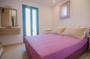
a bedroom with a blue bedspread and white pillows at Ios Sea View in Ios Chora
