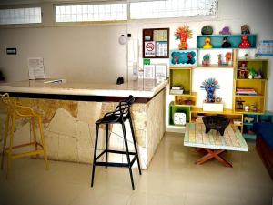a bar in a room with a counter and chairs at Kay Hotel in Playa del Carmen