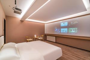 a room with a bed and a projection screen at Floral Hotel Beijing Heyuan Courtyard Luxury Hotel in Beijing