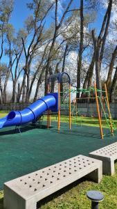 a playground with a blue slide in a park at Departamento 4 personas in Osorno