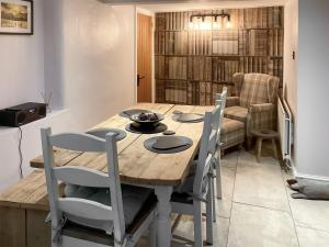 a dining room with a wooden table and chairs at Cosy Cottage in Portinscale