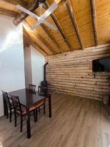 a dining room with a table and chairs and a ceiling fan at Piedras Blancas in La Bajada