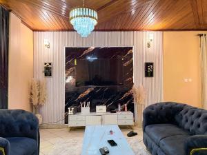 a living room with two couches and a large tv at J&R business sarl in Douala