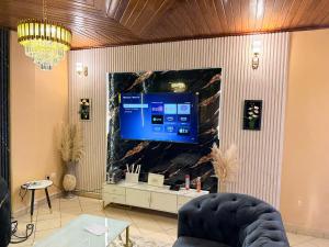 a living room with a large screen tv on a wall at J&R business sarl in Douala