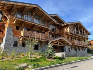 a large wooden building with balconies on a street at Appartement haut de gamme à Courchevel Le Praz avec parking et wifi - FR-1-568-58 in le Praz