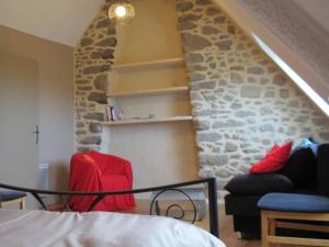 ein Wohnzimmer mit einer Steinwand und roten Stühlen in der Unterkunft Gîte convivial à Guérande avec terrasse au calme - FR-1-306-1318 in Clis