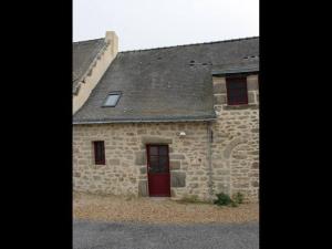 ein Steingebäude mit einer roten Tür und Fenstern in der Unterkunft Gîte convivial à Guérande avec terrasse au calme - FR-1-306-1318 in Clis