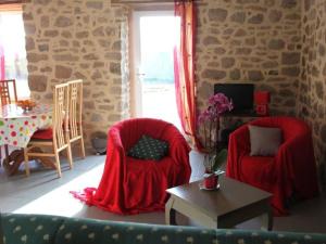 a living room with two red chairs and a table at Gîte au charme de la pierre et des poutres près de Guérande - FR-1-306-1317 in Clis