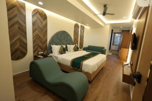 - une chambre avec un lit et une chaise verte dans l'établissement Hotel Heaven Blue, à Rajkot