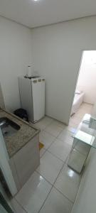 een witte keuken met een aanrecht en een koelkast bij Lac residence 1C in Vitória da Conquista