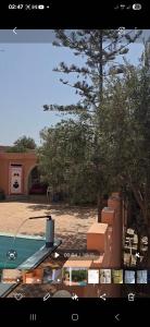 une vue d'une piscine avec des box et un bâtiment dans l'établissement Ferme dar naciri,  6 autres photos