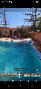 une vidéo d'une piscine avec un écran de télévision dans l'établissement Ferme dar naciri, 