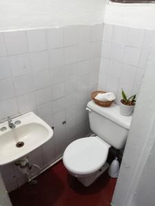 Un baño blanco con inodoro y lavabo. en Miliz City Center, en La Romana