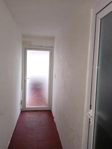 un pasillo vacío con una puerta que conduce a una ventana en Miliz City Center, en La Romana 5 fotos más