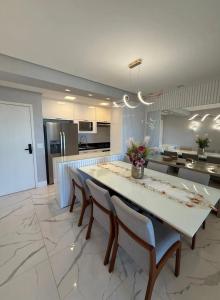 a large kitchen with a large white table and chairs at apartamento luxo Umarizal in Belém
