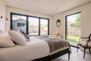 Un dormitorio con una cama grande y grandes ventanales. en Historic 3 Bedroom Cottage in the Cotswolds, en Idbury