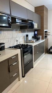 a kitchen with a stove and stainless steel appliances at Casa Jardim Gramado in Cuiabá
