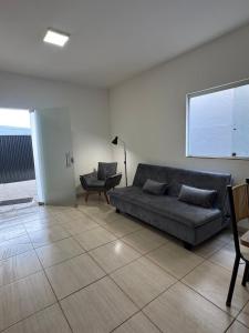 a living room with a couch and a chair at Casa em Sete Lagoas - até 12 pessoas - Preço Justo in Sete Lagoas