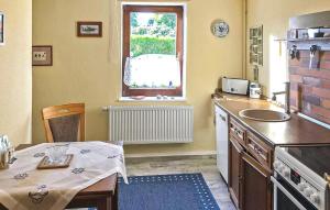 a kitchen with a table and a sink and a window at Ferienwohnung Altenkirchen in Altenkirchen +11 photos