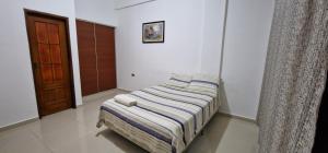 a small bed in a room with a door at Villa flor in Santa Cruz de la Sierra