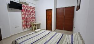 a bedroom with a bed and a television in it at Villa flor in Santa Cruz de la Sierra