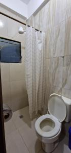 a bathroom with a white toilet and a window at Villa flor in Santa Cruz de la Sierra
