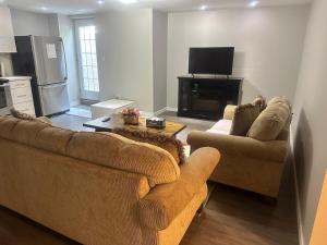 ein Wohnzimmer mit zwei Sofas und einem Fernseher in der Unterkunft Beautiful&Spacious 2 Bedroom Basement Family Suite in Bradford
