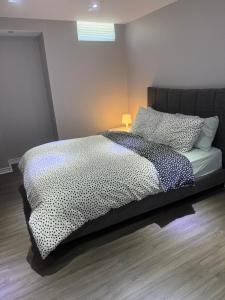 ein Schlafzimmer mit einem Bett mit einer schwarz-weißen Bettdecke in der Unterkunft Beautiful&Spacious 2 Bedroom Basement Family Suite in Bradford