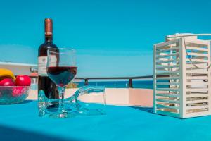 uma garrafa de vinho e um copo sobre uma mesa em Oreia em Palaiochora