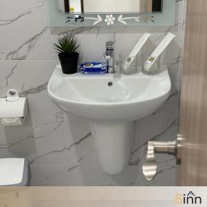 a white sink in a bathroom with a mirror at 8inn hostel  +25 photos