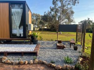 a tiny house with a window and a bench at D&L Cottage by Tiny Away in Munno para Downs +3 photos