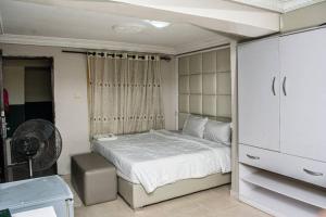 a bedroom with a bed and a dresser in it at Duban International Hotels Ltd in Omole