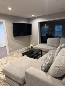 Una sala de estar con dos sofás y un televisor de pantalla plana. en Calm & Cozy Modern Escape, en Atlanta