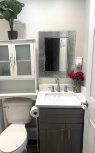 Un baño con lavabo, inodoro y espejo. en Calm & Cozy Modern Escape, en Atlanta