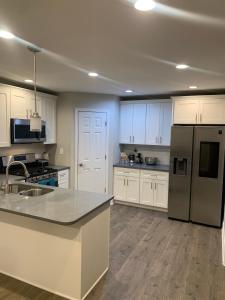 Una cocina con gabinetes blancos y electrodomésticos de acero inoxidable. en Calm & Cozy Modern Escape, en Atlanta