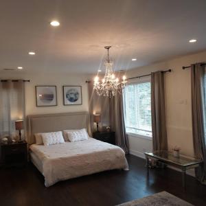 une chambre avec un grand lit et un lustre dans l'établissement Chicago NorthShore Luxury Private Vacation Rental, à Wilmette