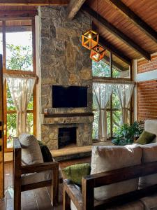 sala de estar con sofá y chimenea de piedra en Cabaña Xamixkali, en Zacatlán